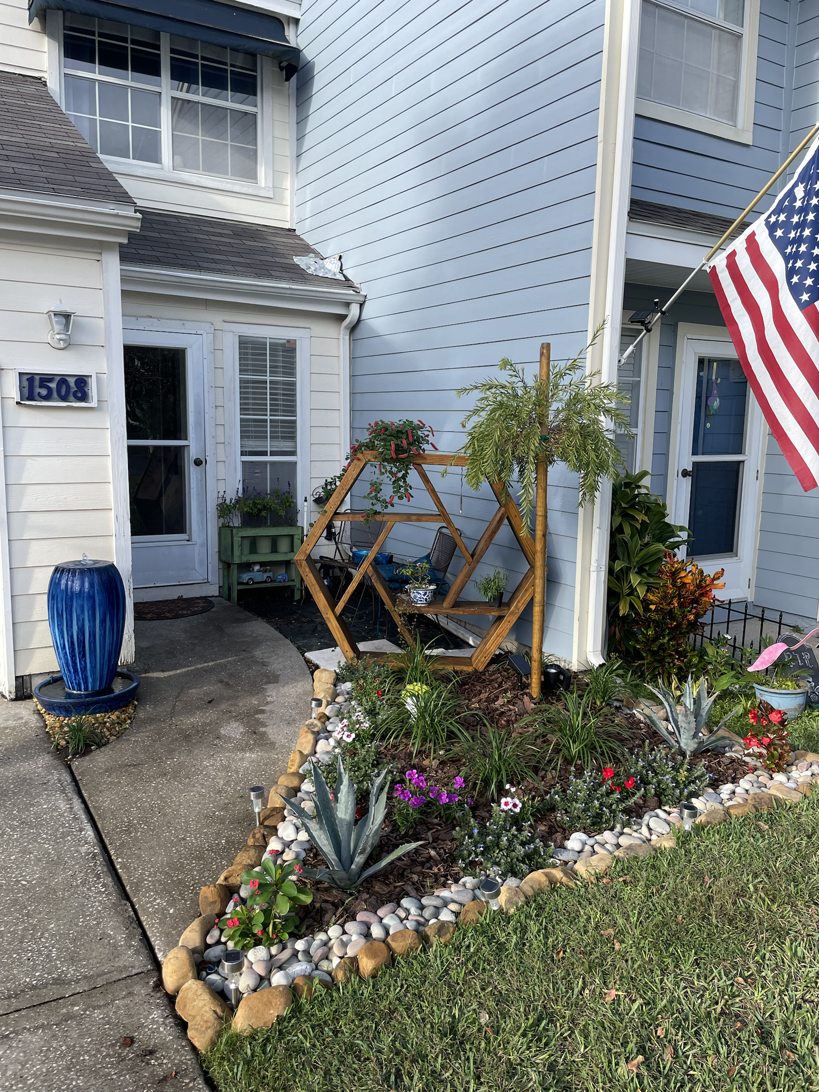 Entry garden with stone border and geometric wood feature